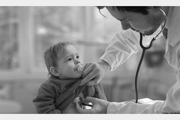 Doctor using stethoscope to listen to baby's heart
