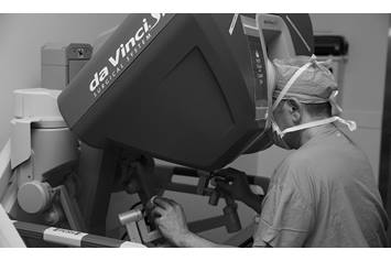 Surgeon using robotics.