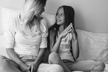 mother and daughter sitting on a couch