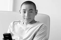 Teenage Boy Lounging with Cell Phone in Hand