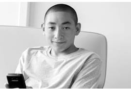 Teenage Boy Lounging with Cell Phone in Hand