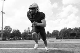 A football player gains momentum, running forward