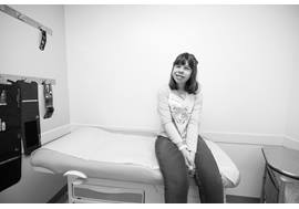 Young adolescent with Williams syndrome sitting in patient room of hospital.