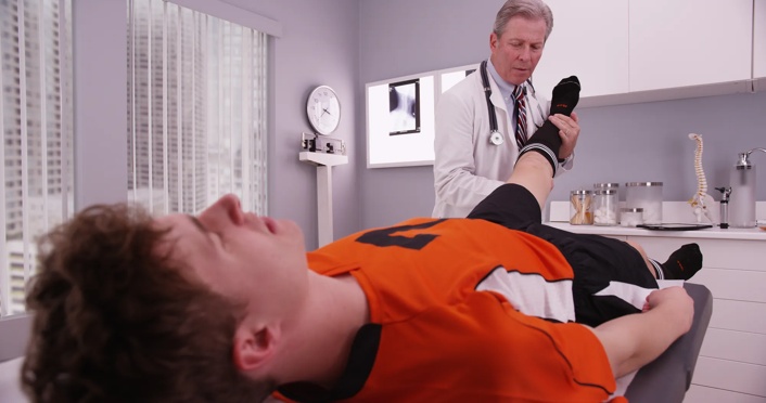 doctor examining a teenage boy's leg