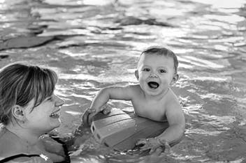 Baby swimming in a pool.