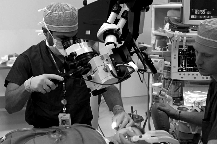 Physician performing ear tube surgery on a child.