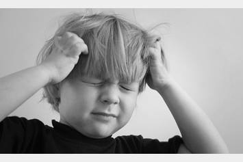 young boy frustrated pulling his hair