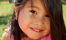 Young girl smiling with pierced ears.