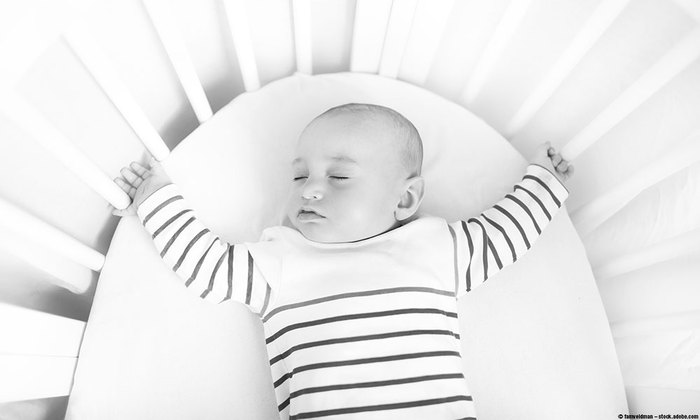 Baby sleeping on his back in a crib