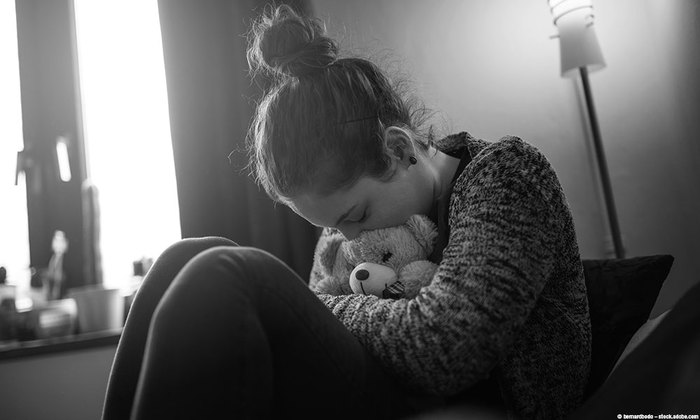 Teenage girl hugging a teddy bear