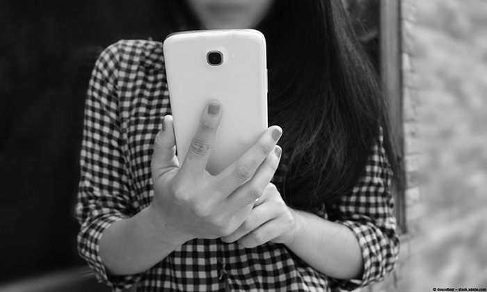 Teenager holing smart phone.