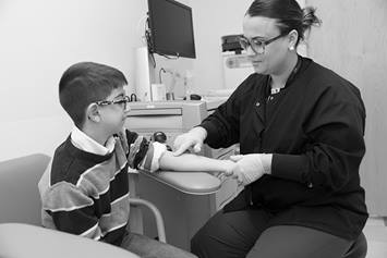 image of boy getting blood drawn in a lab