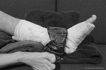image of an ankle wrapped in a bandage with ice on it