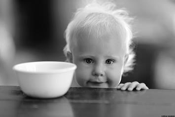 Baby sitting at a table with a bowl