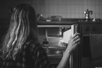 Teenage girl looking into the refrigerator