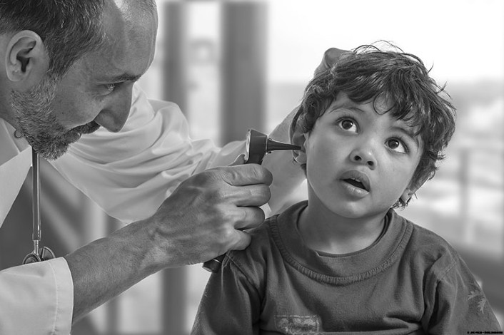 Doctor examining child's ear