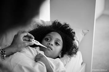 child getting their temperature taken.