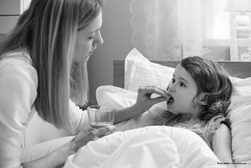 Parent giving a child a medication.