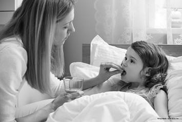 Parent giving a child a medication.