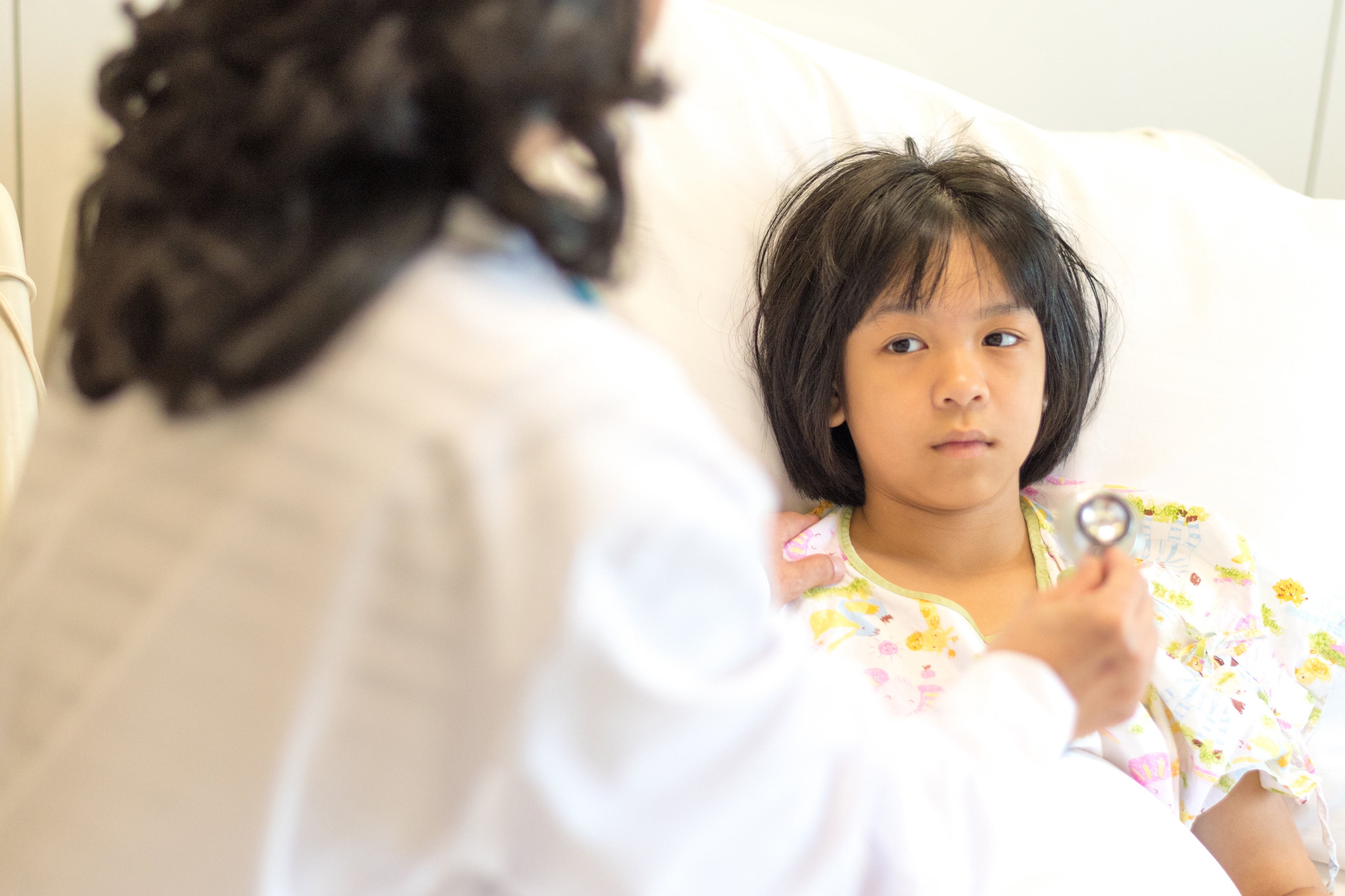 child laying in hospital bed