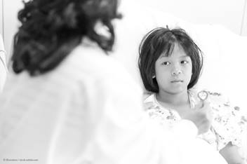 child laying in hospital bed