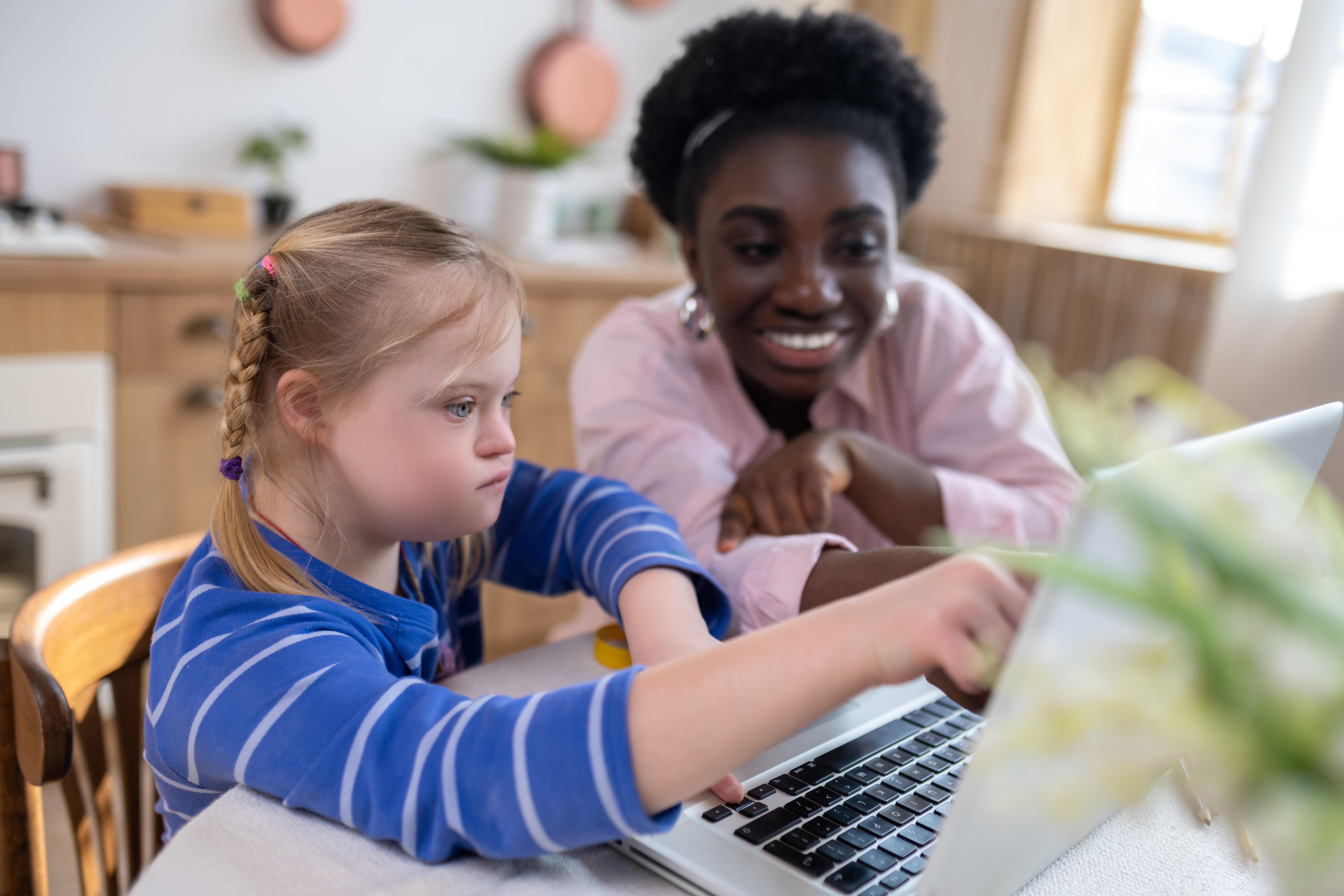 teacher and student looking at a laptop