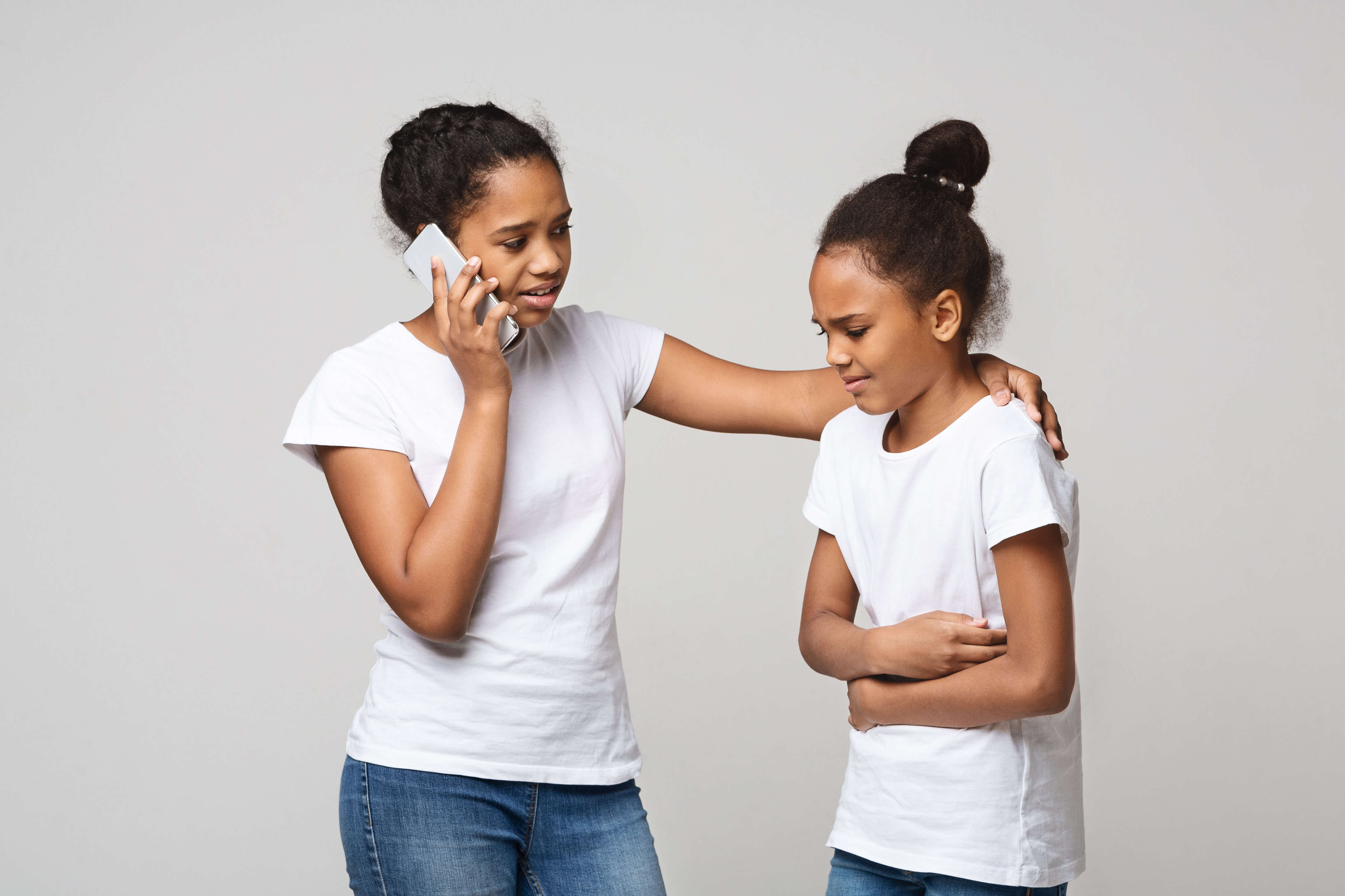 mother on the phone while her child is gripping her stomach