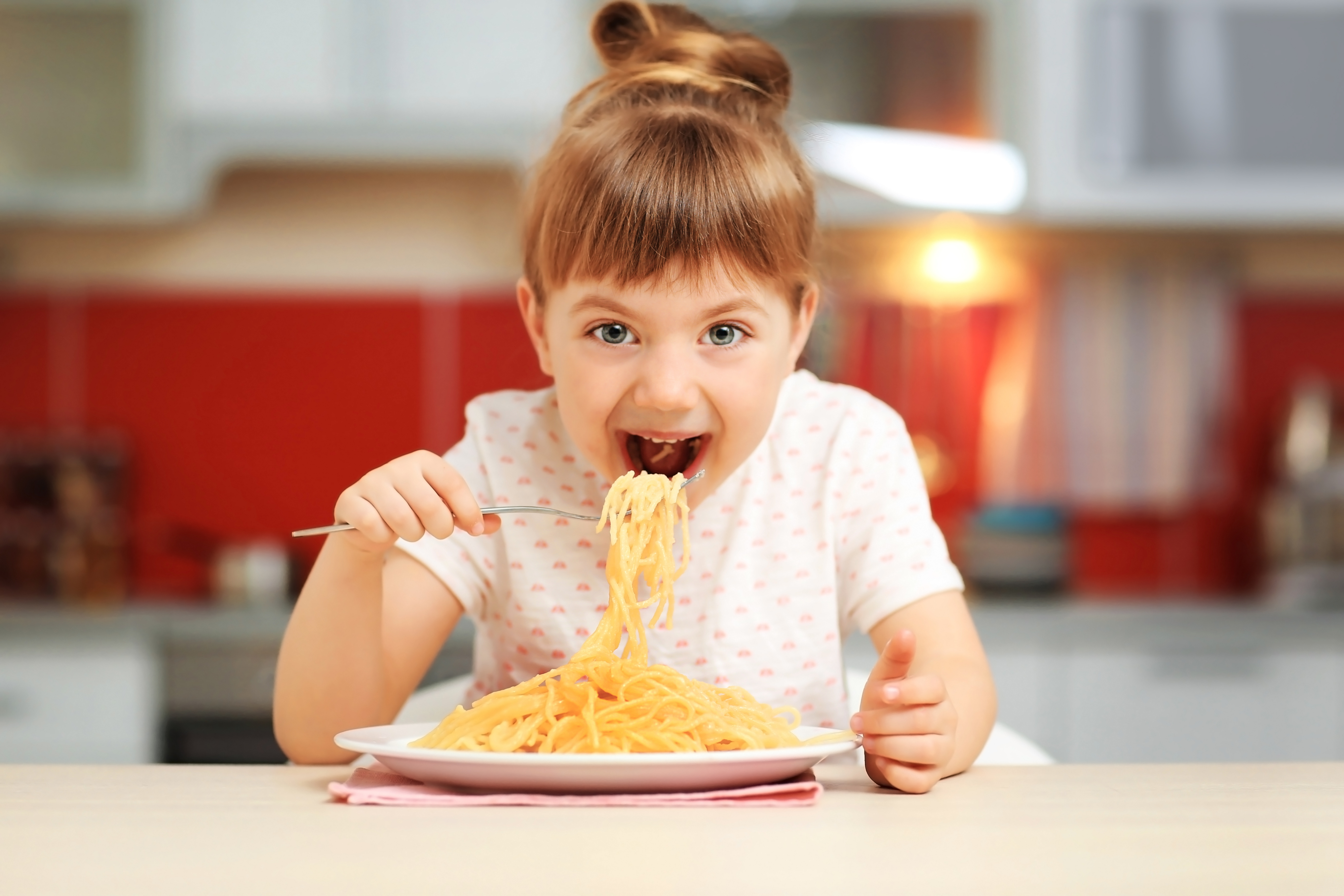 young girl eating a big plate of spaghetti