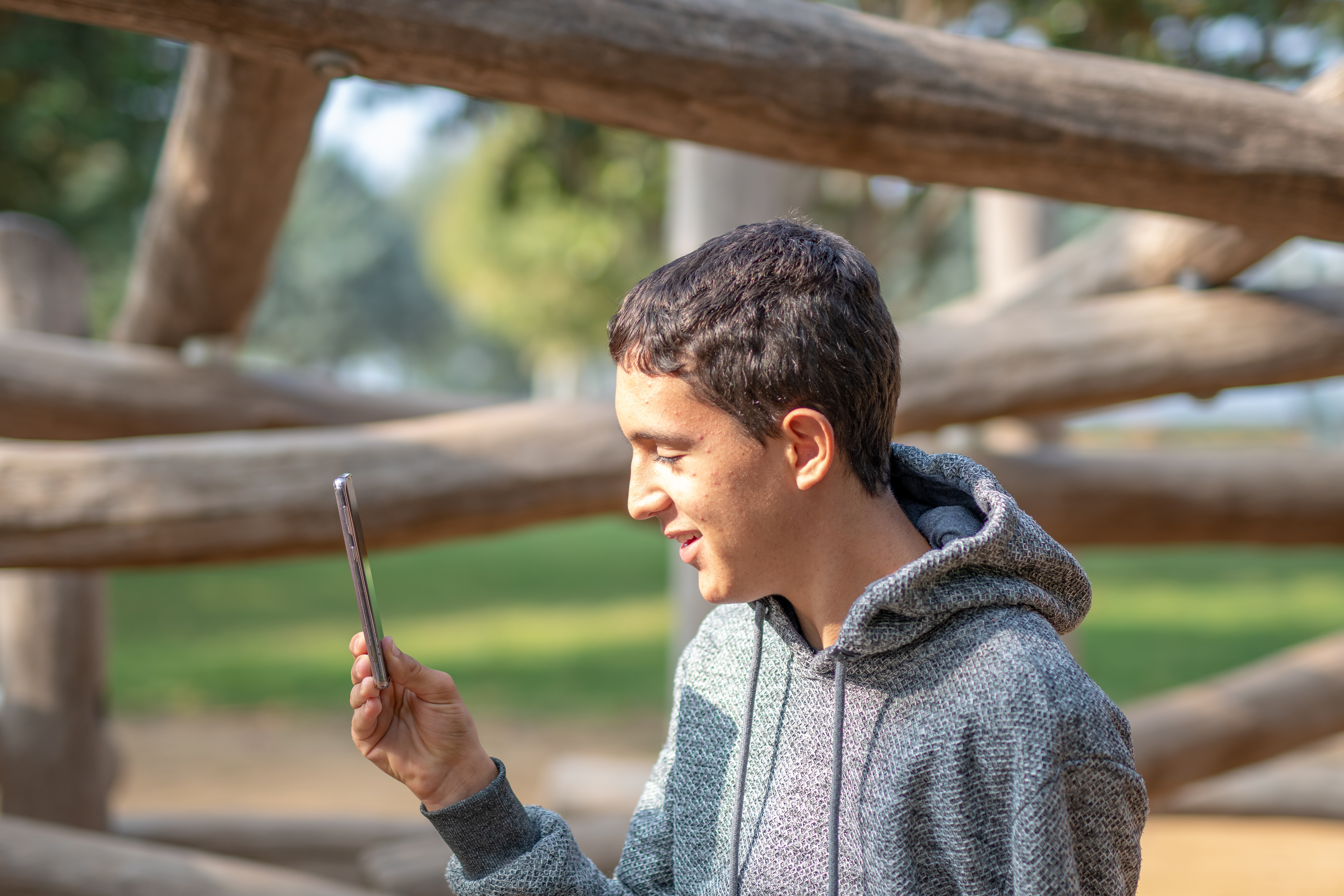 child looking at a phone outside