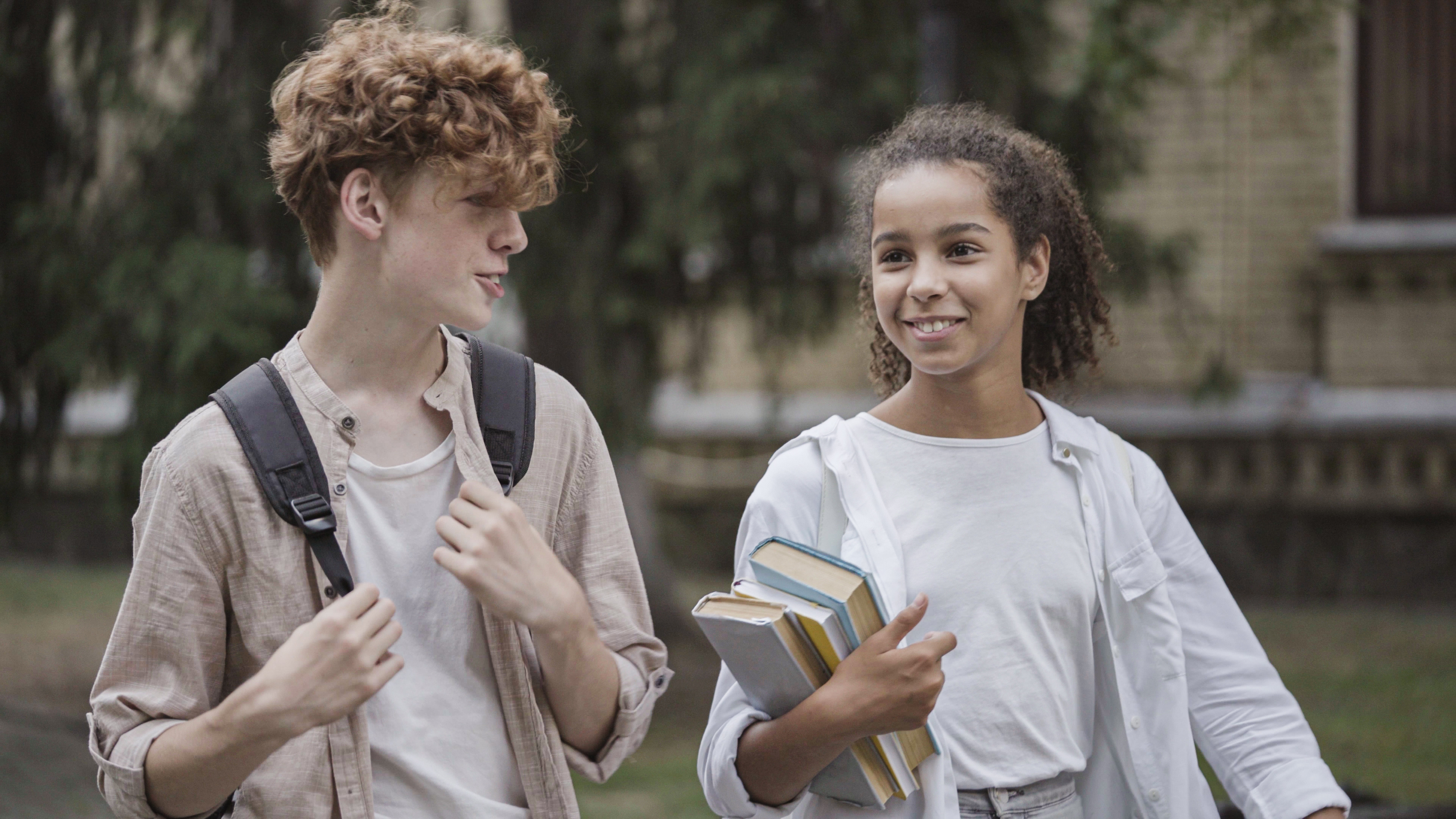teen boy and teen girl walking and talking together