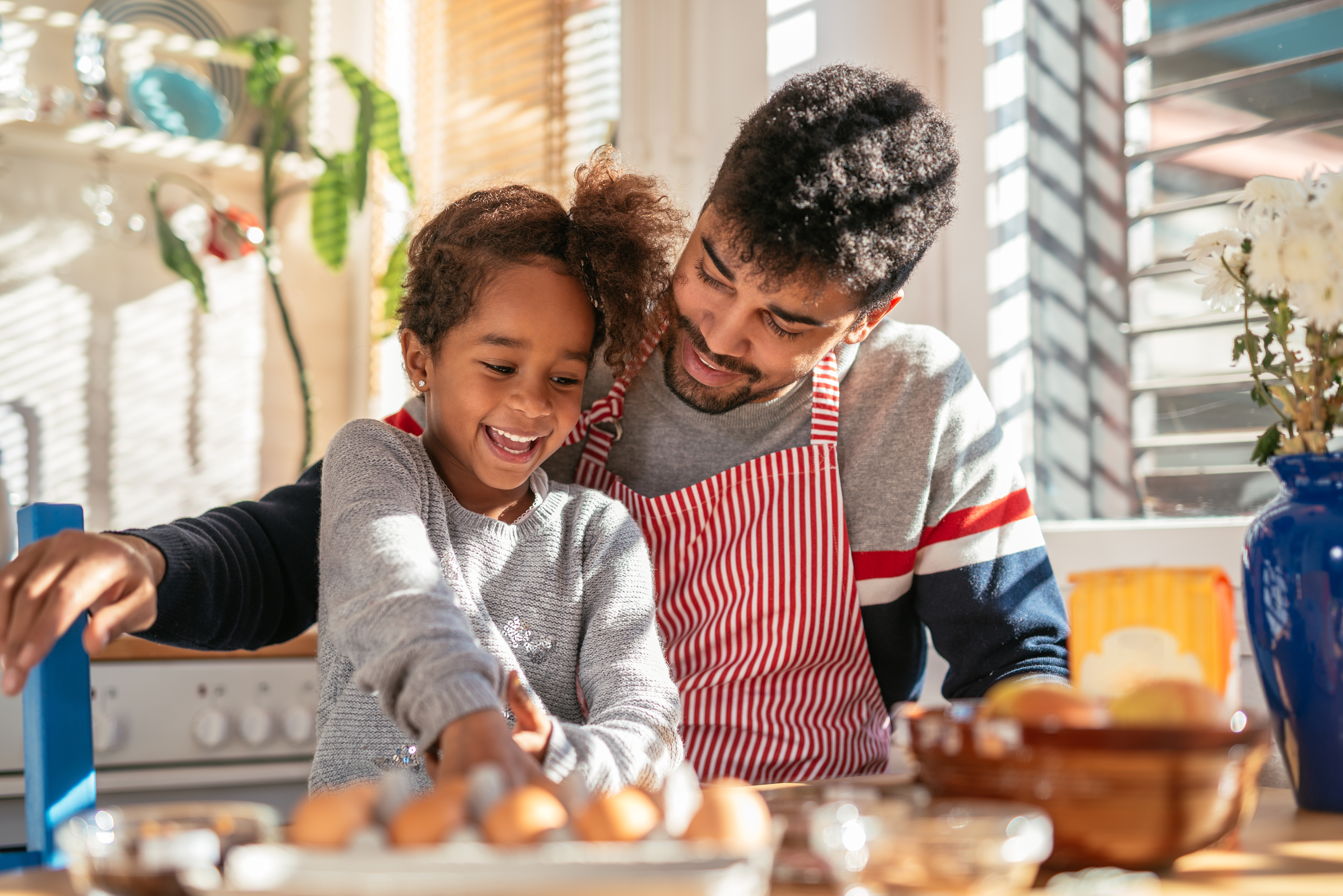 father and daughter cooking together in a kitchen