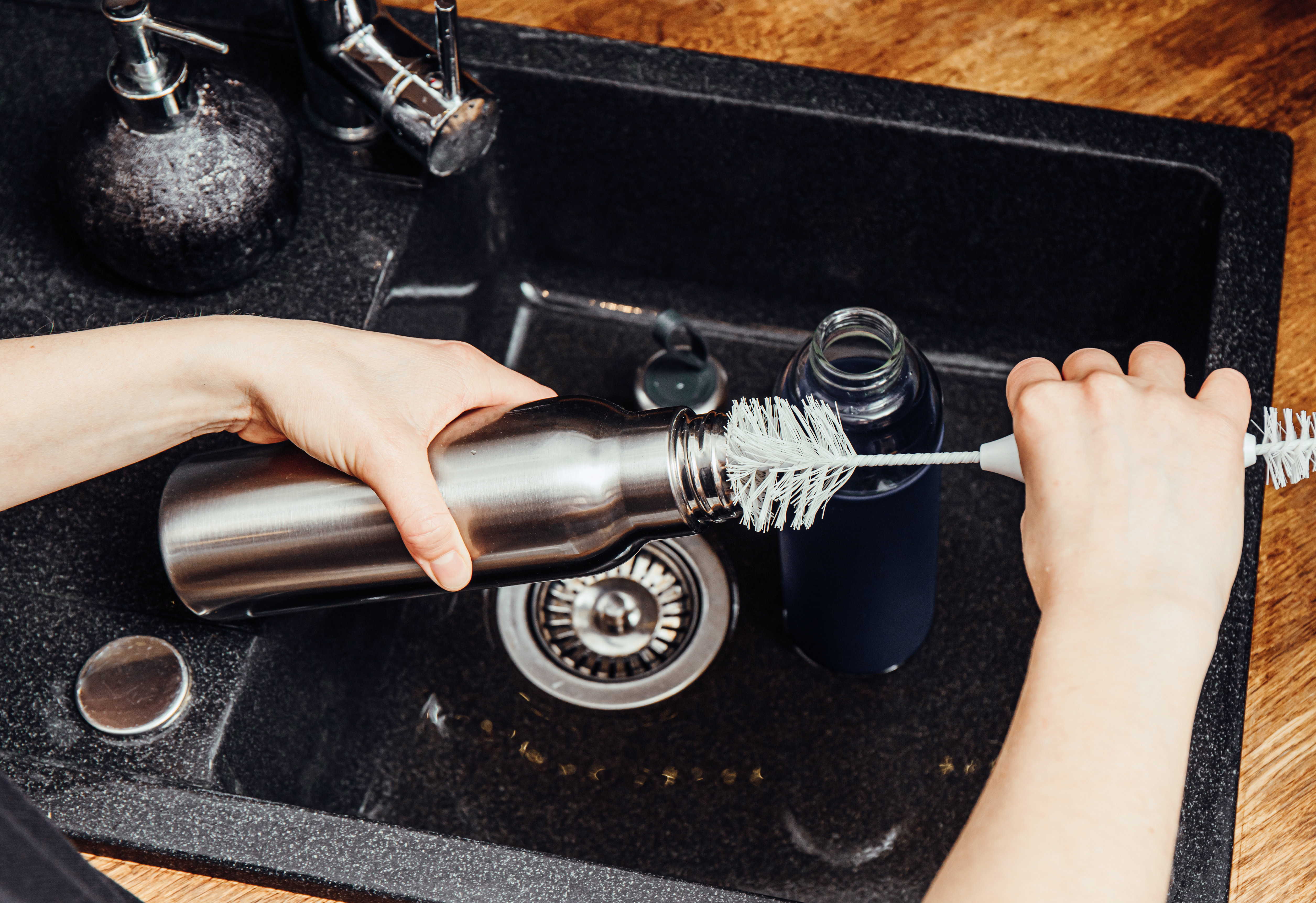 a person cleaning a water bottle