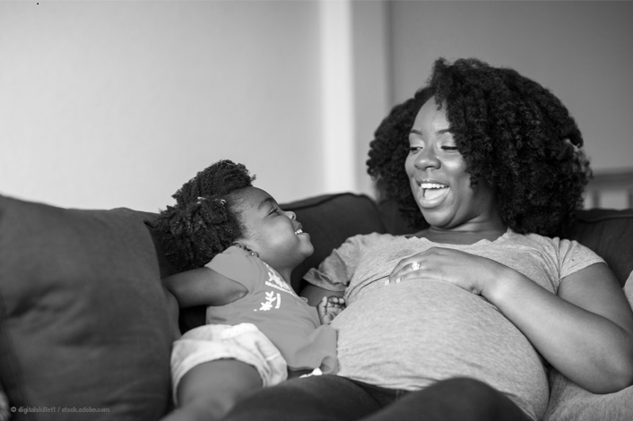 mother and child sitting on the couch smiling