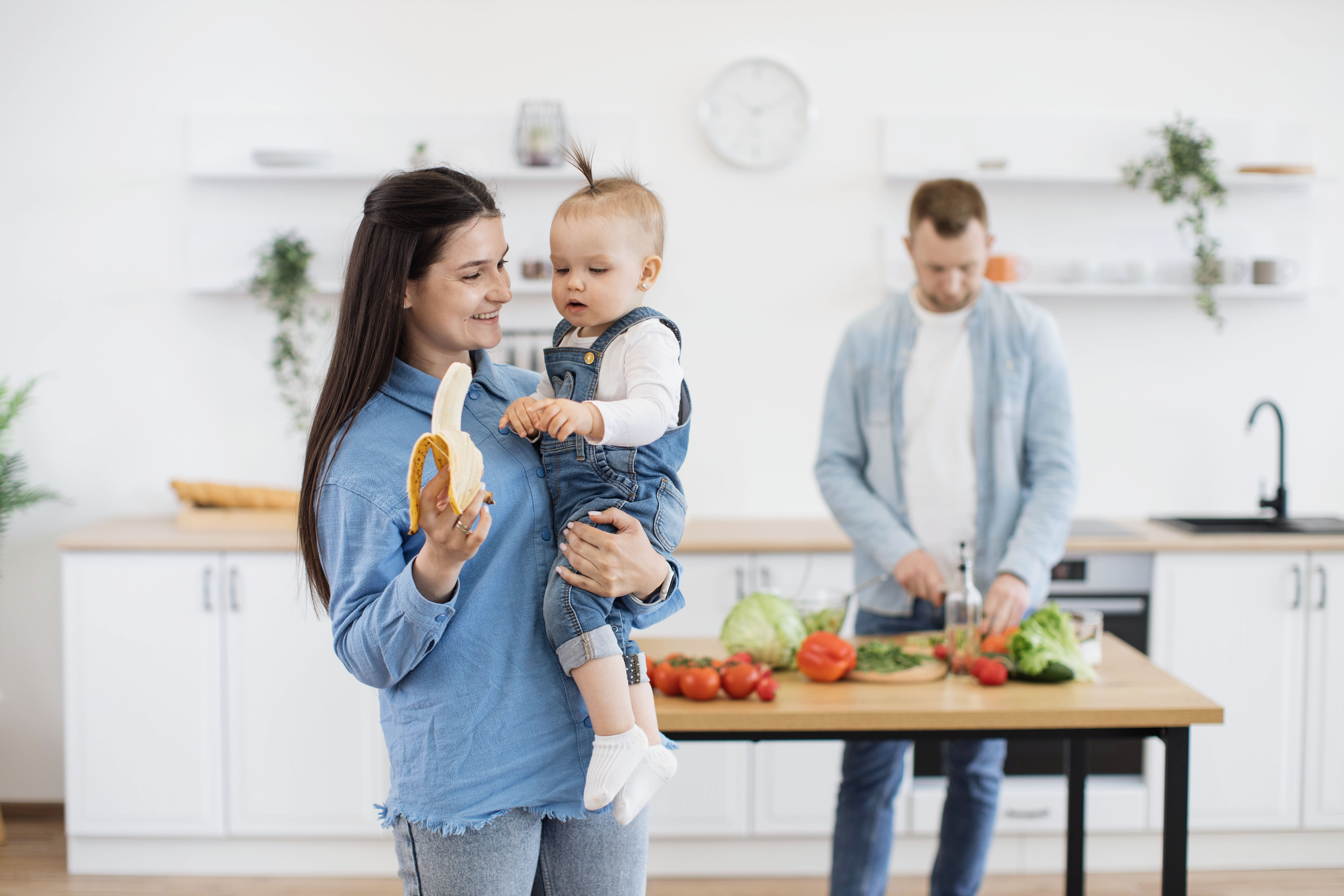 mom holding a banana and baby