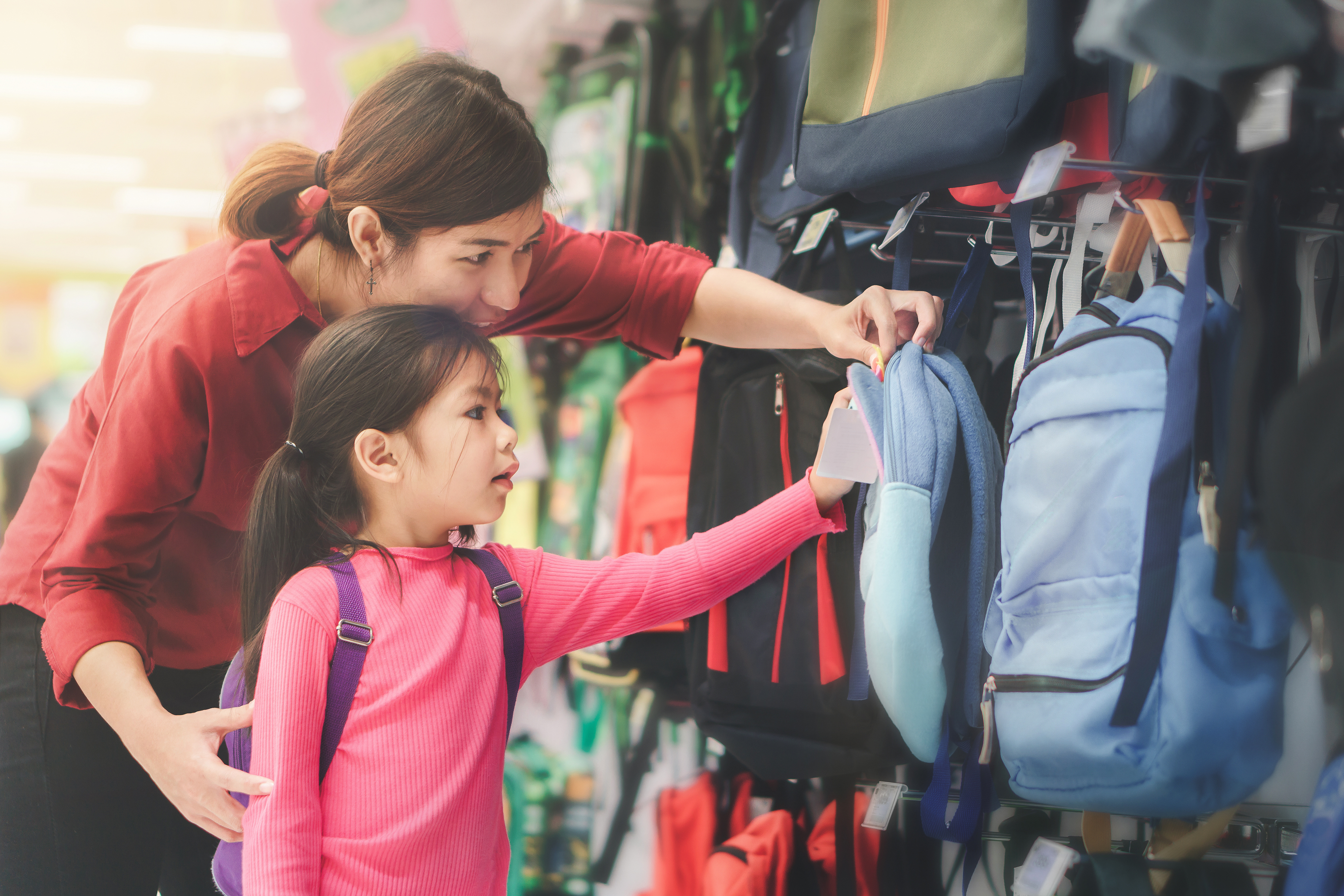 mom and girl looking at backpacks