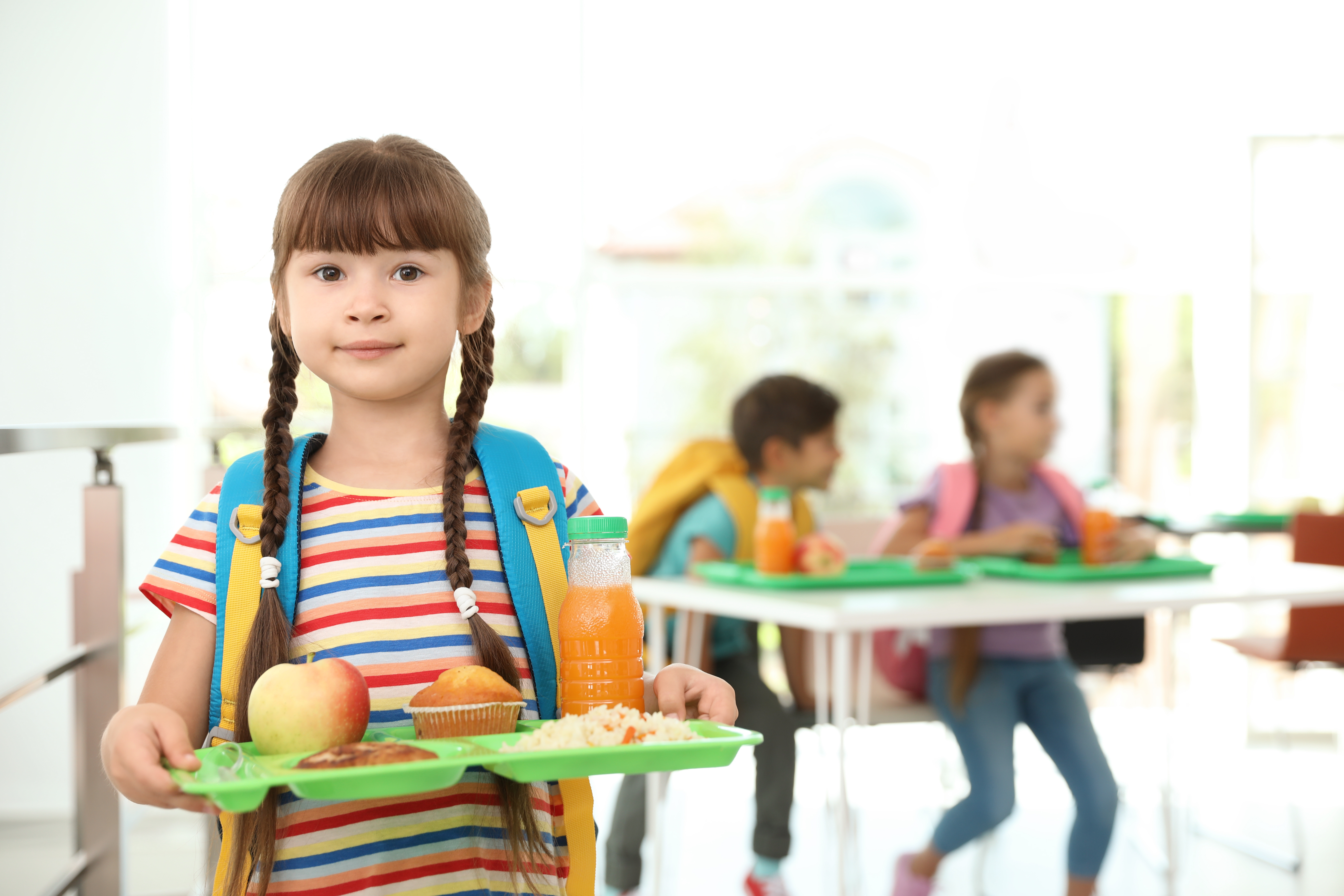 young girl holding a lunch tray