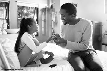 Father is taking his daughter's blood sugar