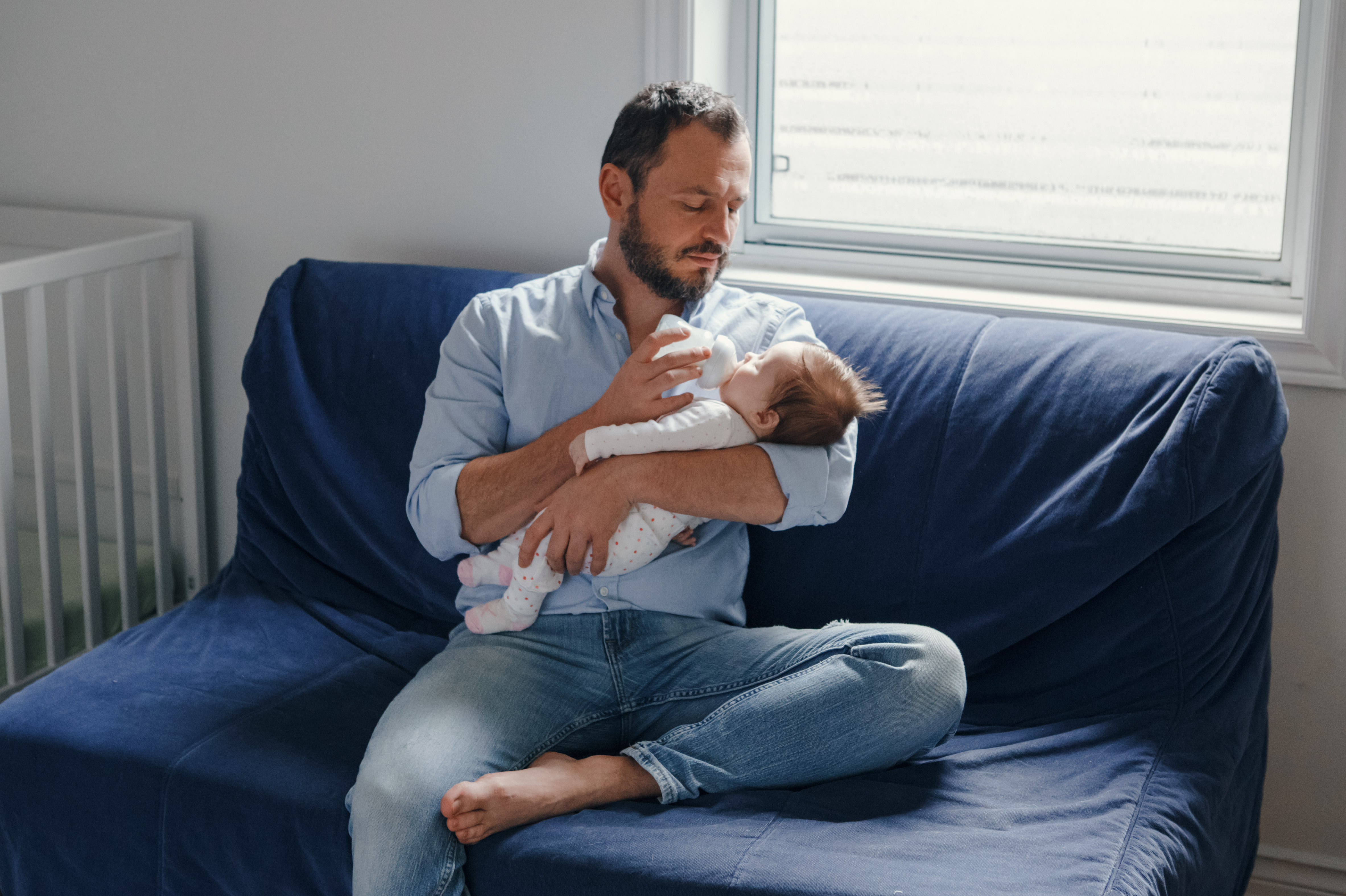 father feeding his baby with a bottle of formula