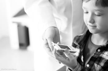 young boy checking his blood sugar with the doctor's assistance