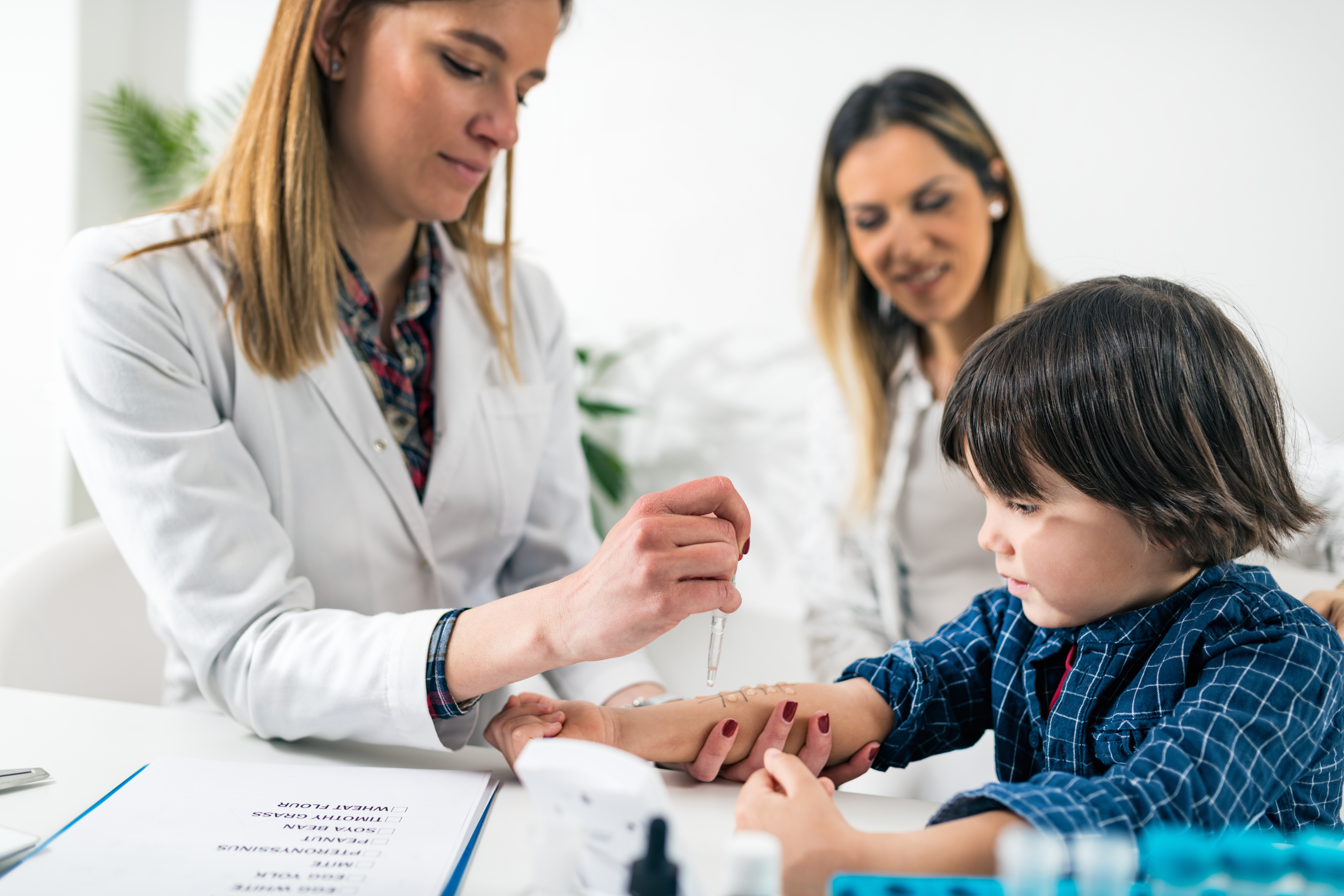 A provider is assisting a young child with their epipen.