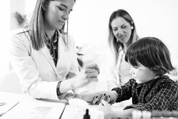 A provider is assisting a young child with their epipen.