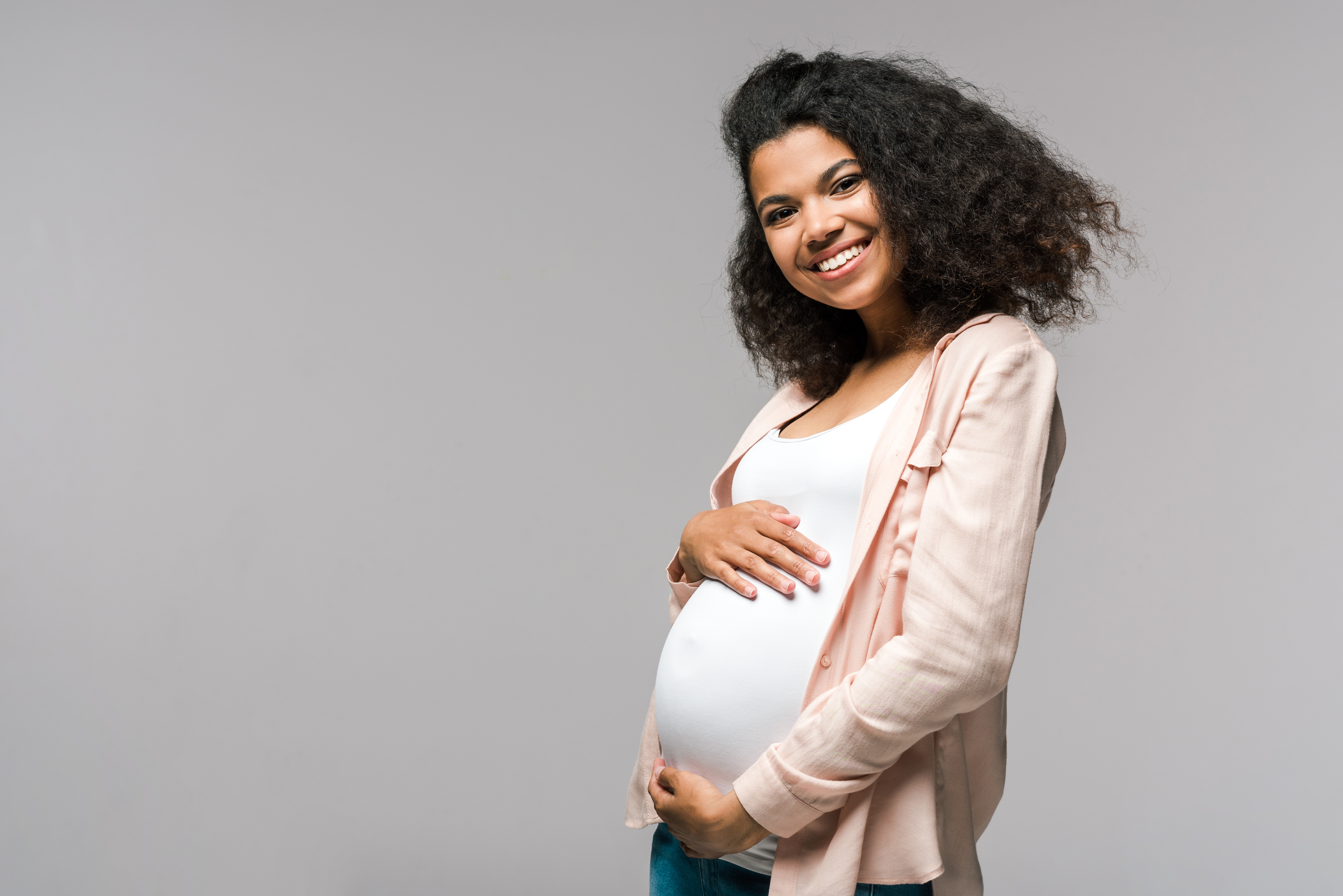 young pregnant woman smiling at the camera