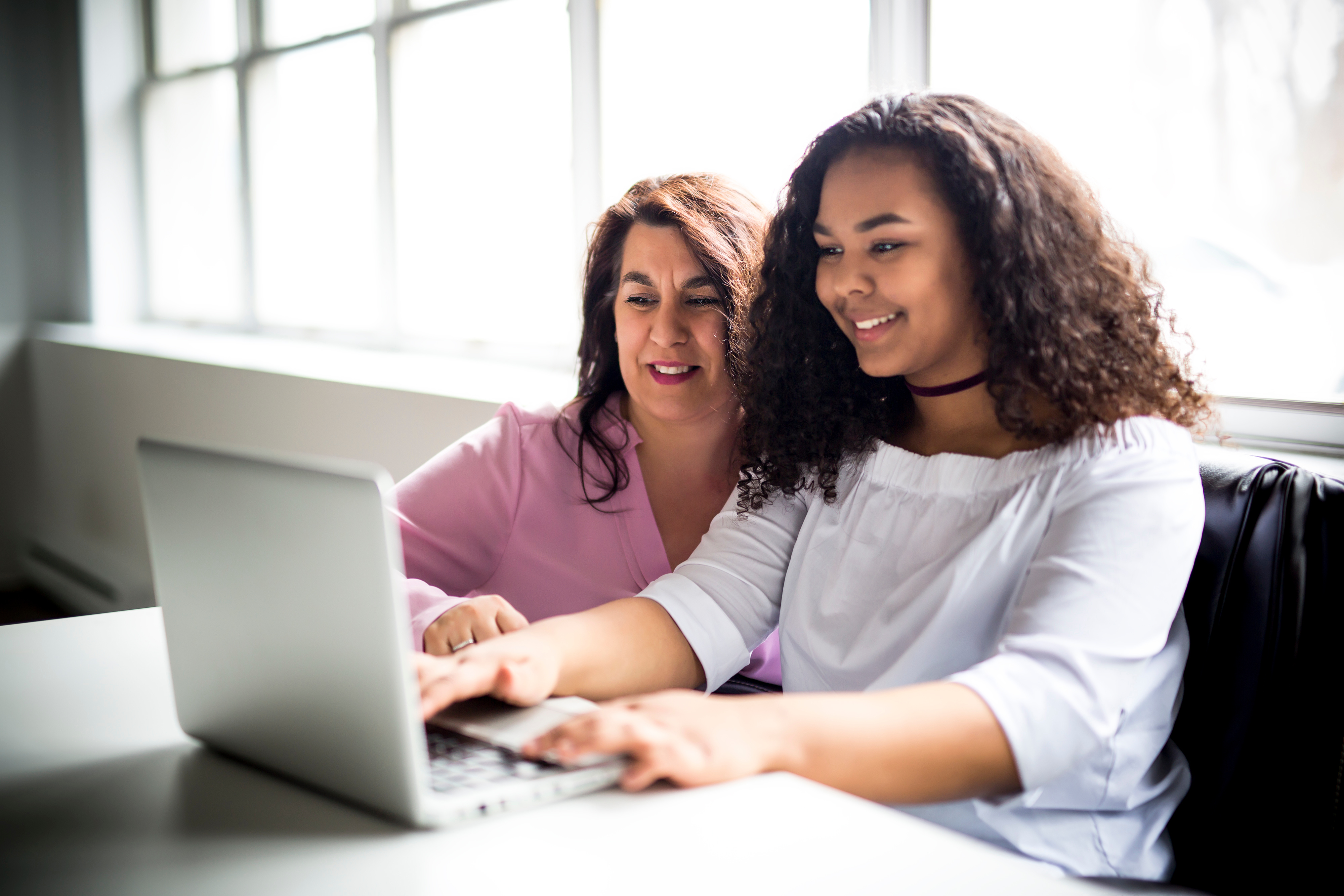 young girl and woman on a laptop