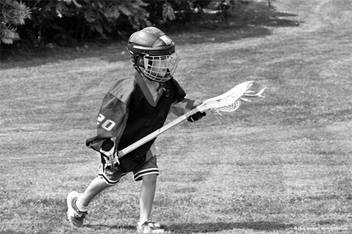 young boy playing lacrosse