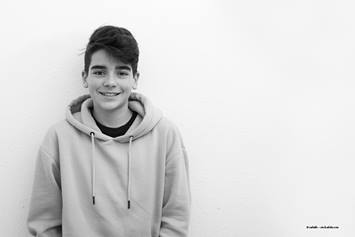 young boy in a sweatshirt smiling at the camera