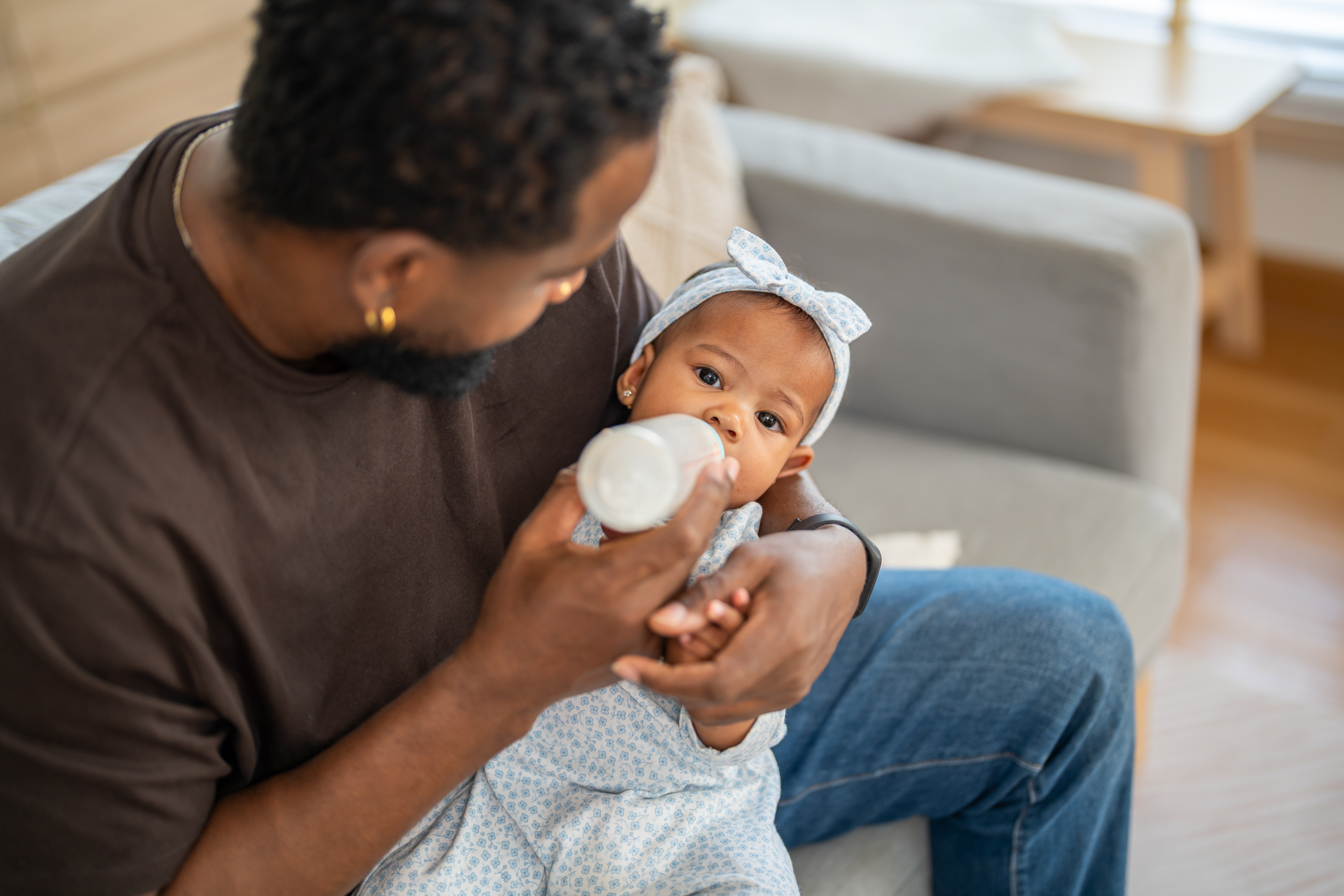 Father feeding is baby formula through a bottle