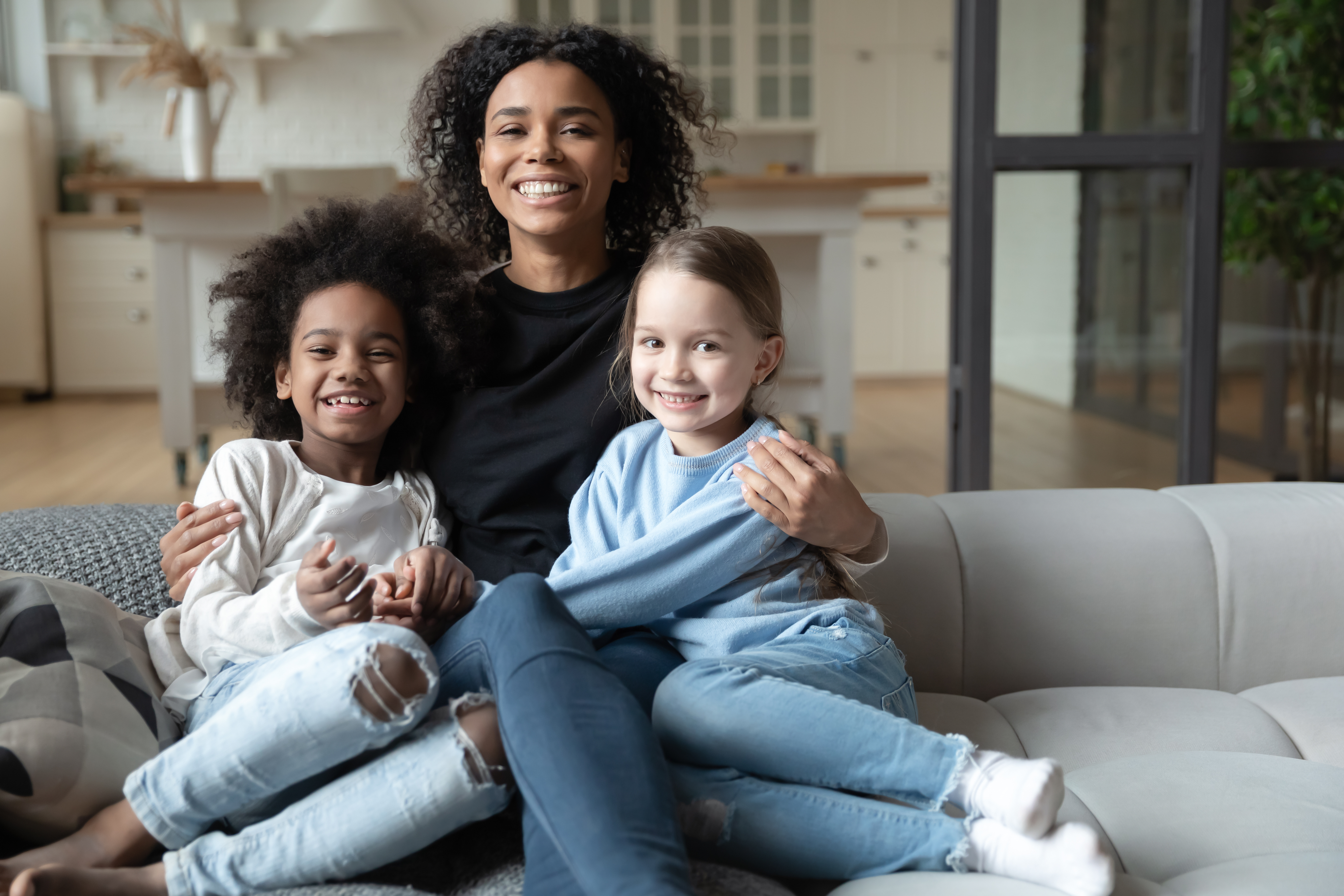 Woman holding two little girls and smiling