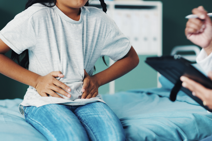 child holding their stomach in pain