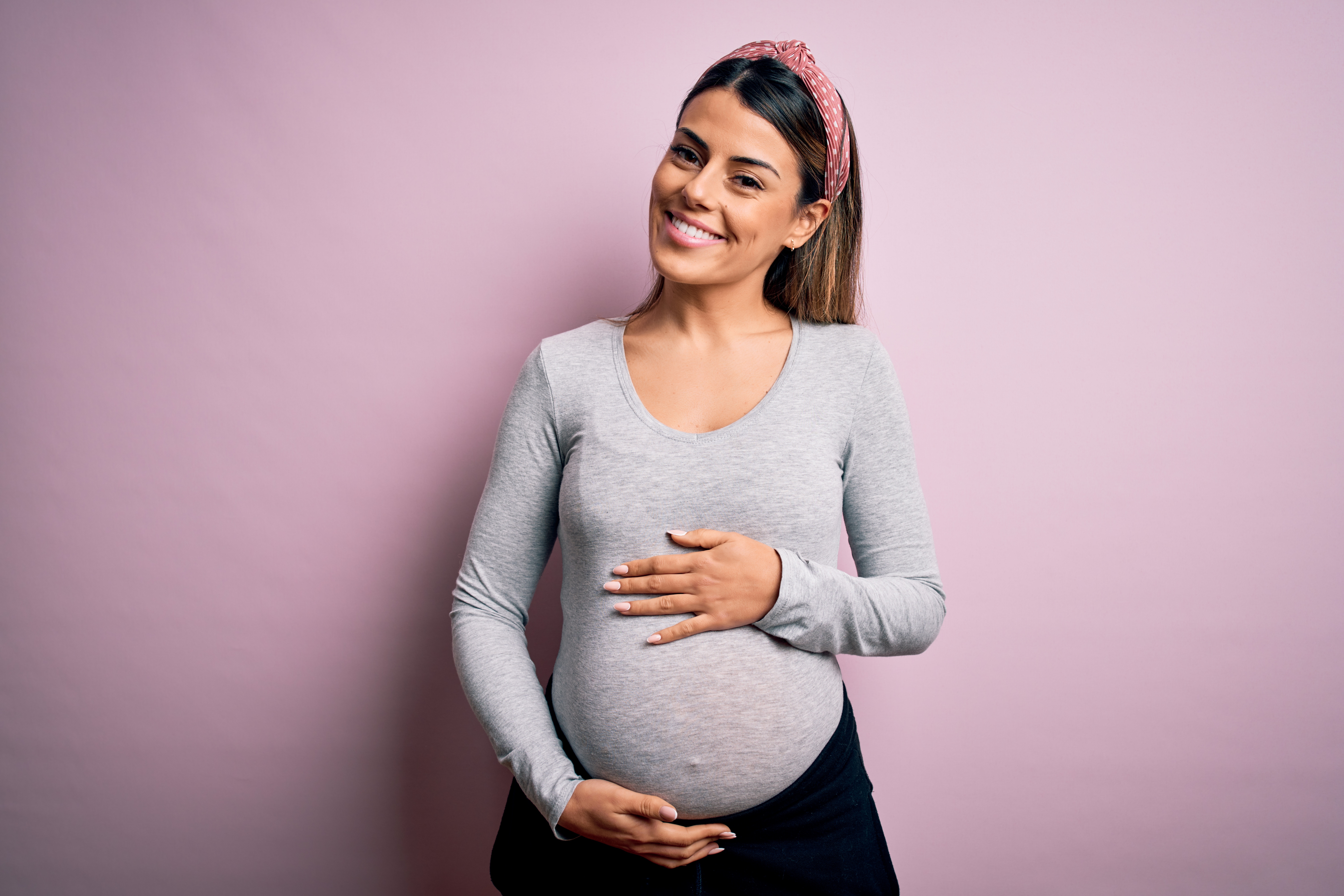 Pregnant lady smiling holding her belly