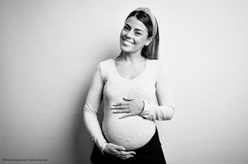 Pregnant lady smiling holding her belly